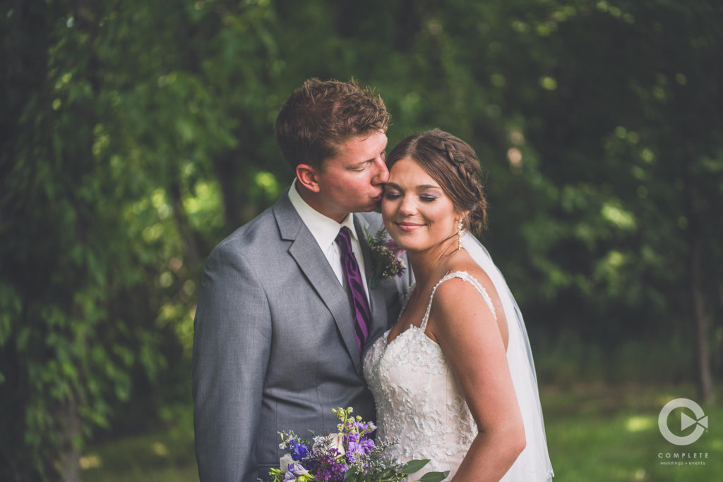 groom kisses bride complete weddings and events photography