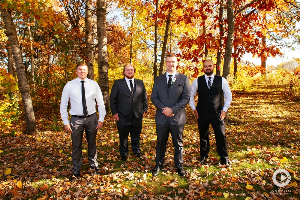 Groomsmen posing together during fall time wedding