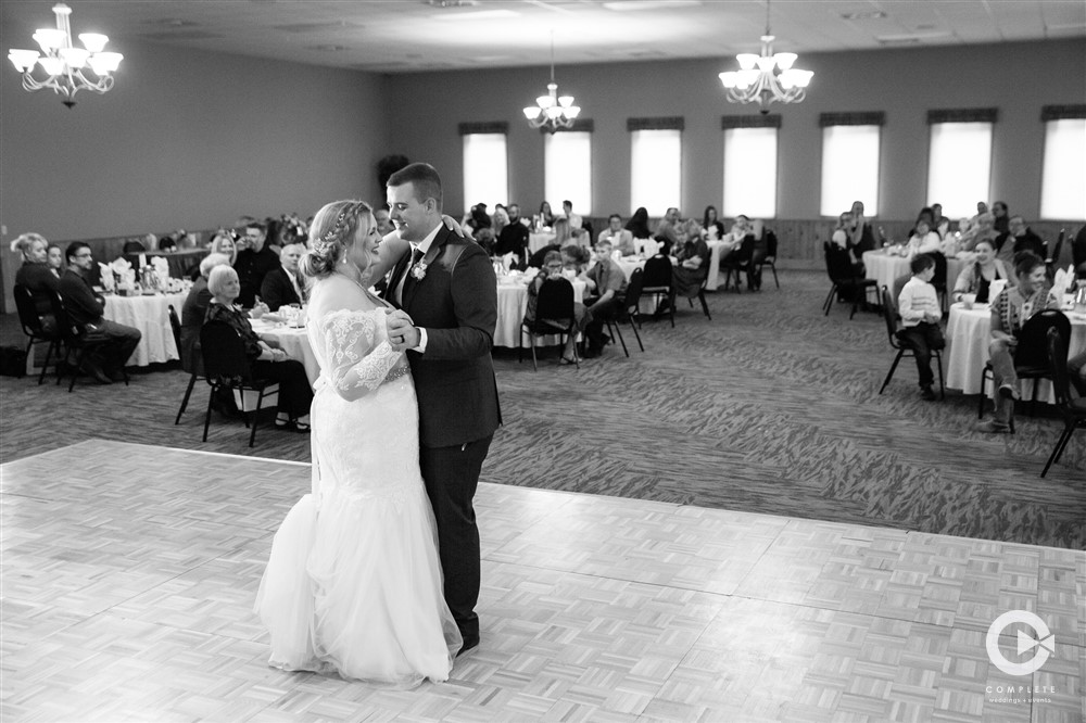 Bride and groom sharing their first dance together on wedding day black and white