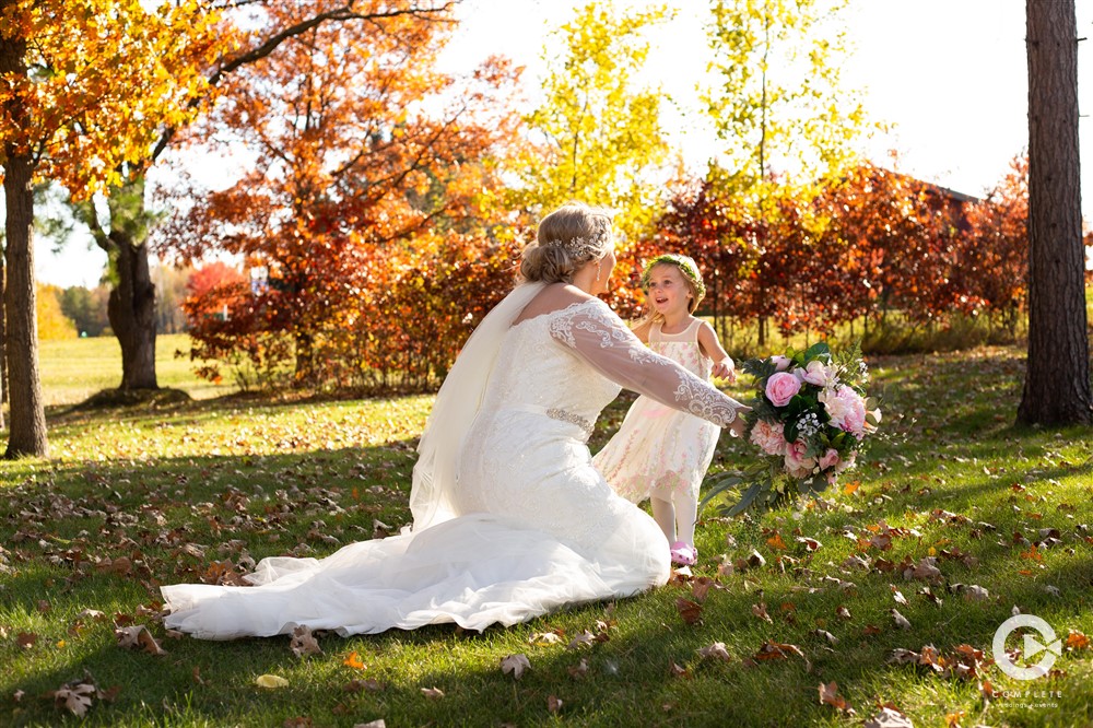 Flower girl running into bride's arms