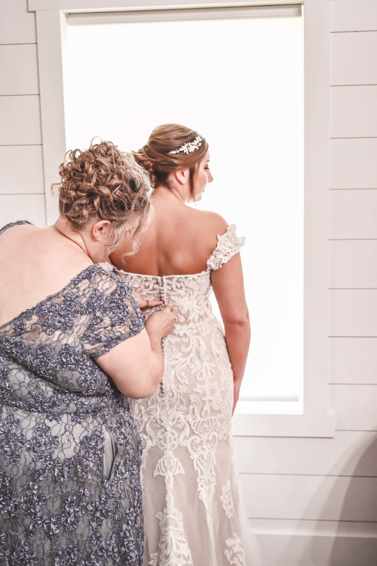 Complete Weddings + Events, Bride, Mother of Bride zipping up bride