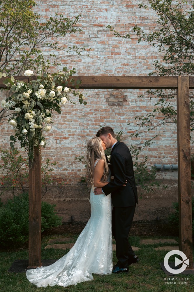 Complete + Weddings Events Photography, Wedding ceremony photos, bride and groom kissing, first kiss