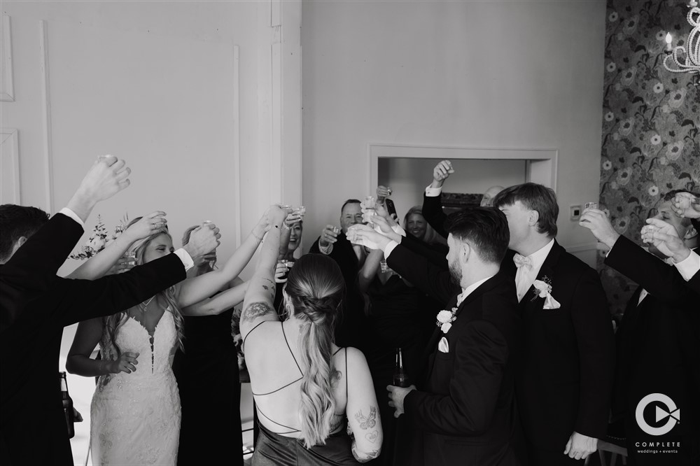 Complete + Weddings Events Photography, Wedding portraits, bride and groom toasting with wedding party