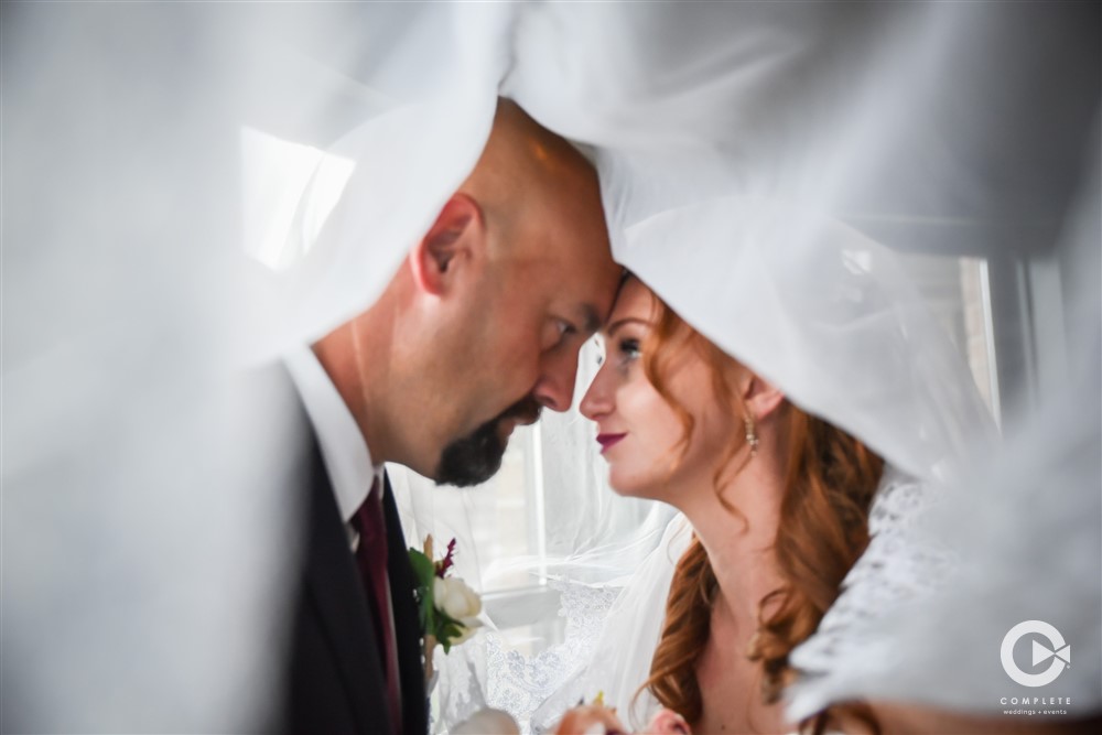 Bride and groom wedding photo under veil