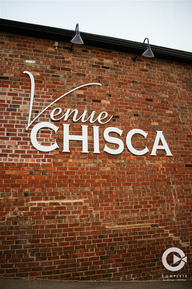 Venue Chisca spelled out on brick wall wedding venue
