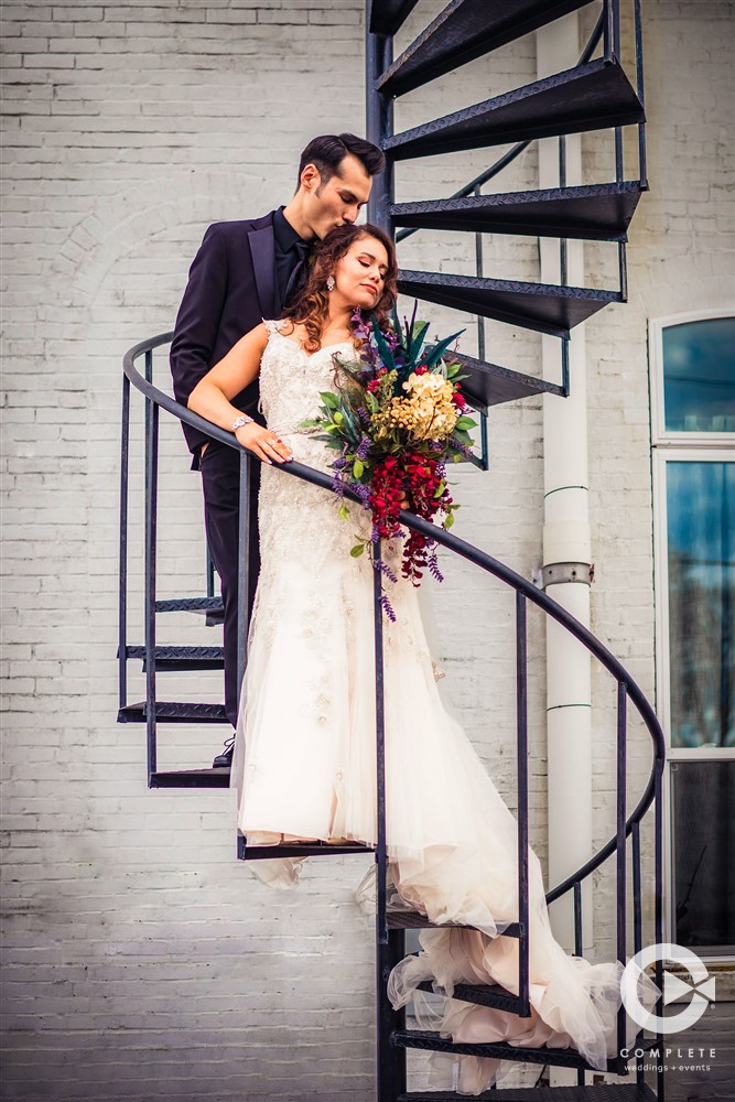 couple holding on staircase