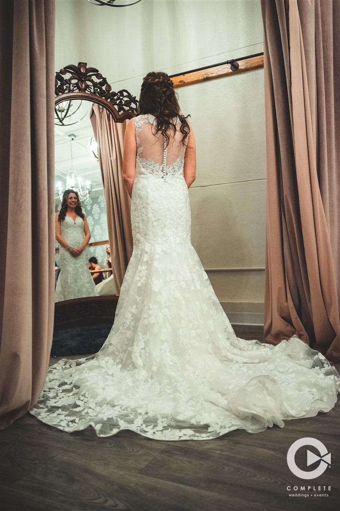 bride looks in mirror in white dress