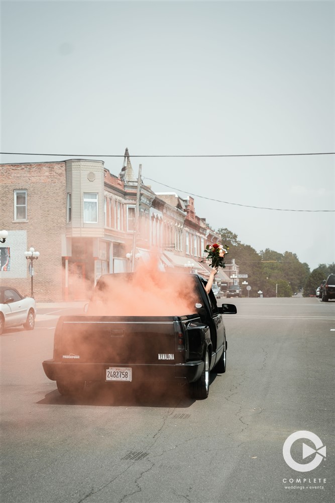 Complete Weddings + Events Photography, Weddings portraits, bride and groom driving off, wedding smoke bomb photo