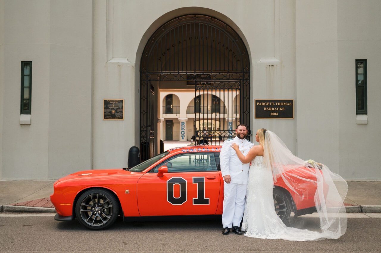 Bride and groom sharing a romantic wedding portrait beneath a historic stone archway in Charleston, South Carolina. Elegant Charleston wedding photography with timeless architecture and natural greenery.