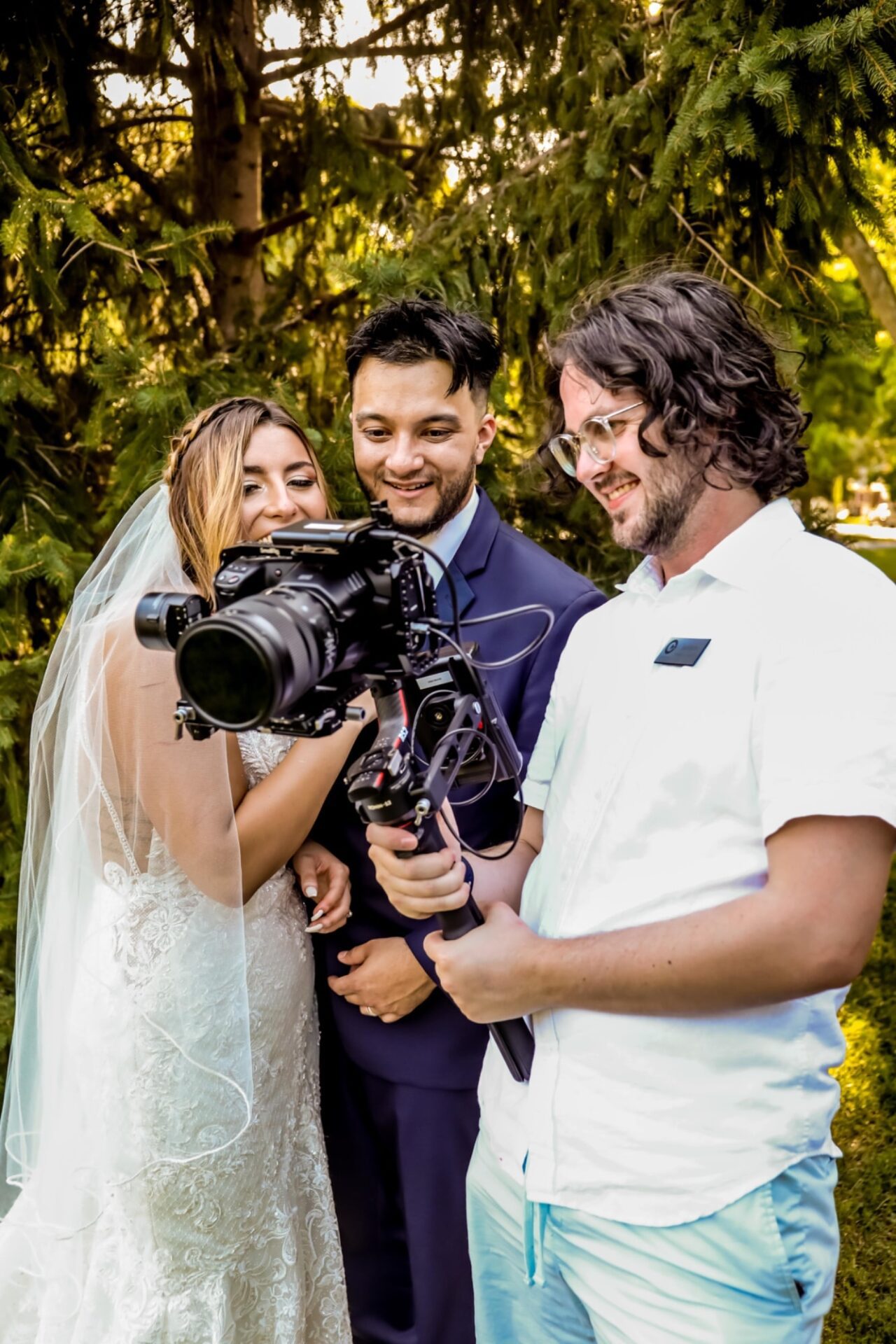 Videographer showing a bride and groom footage on a camera screen