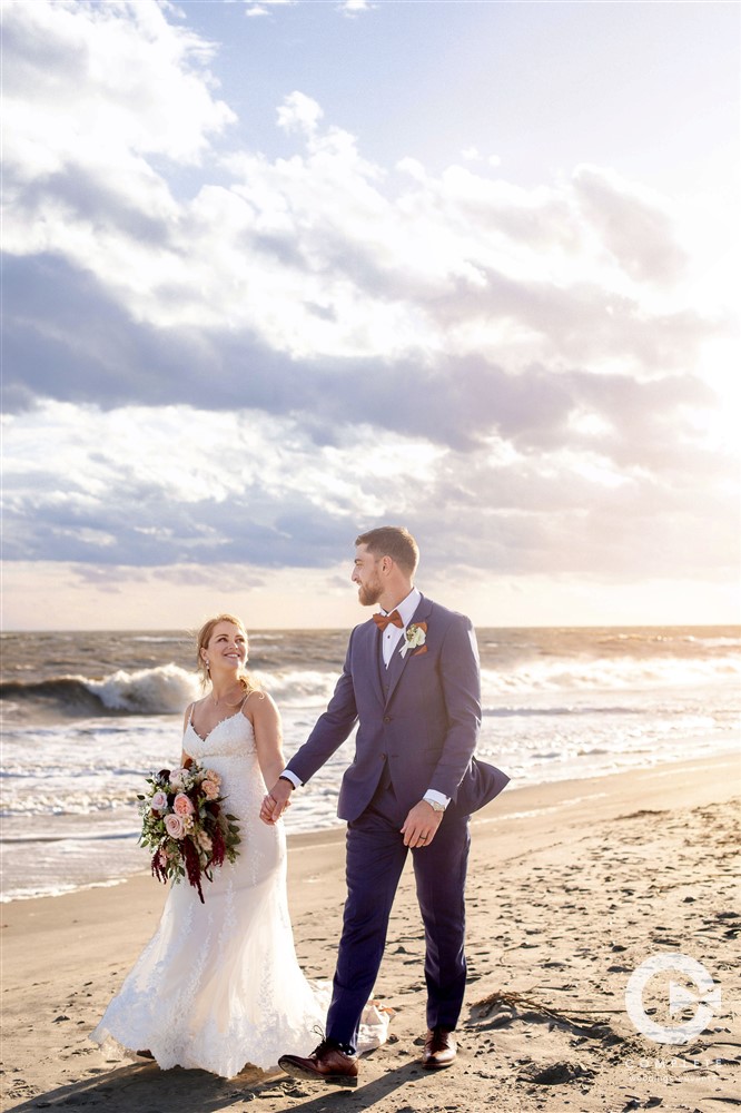 bride and groom walk down beach