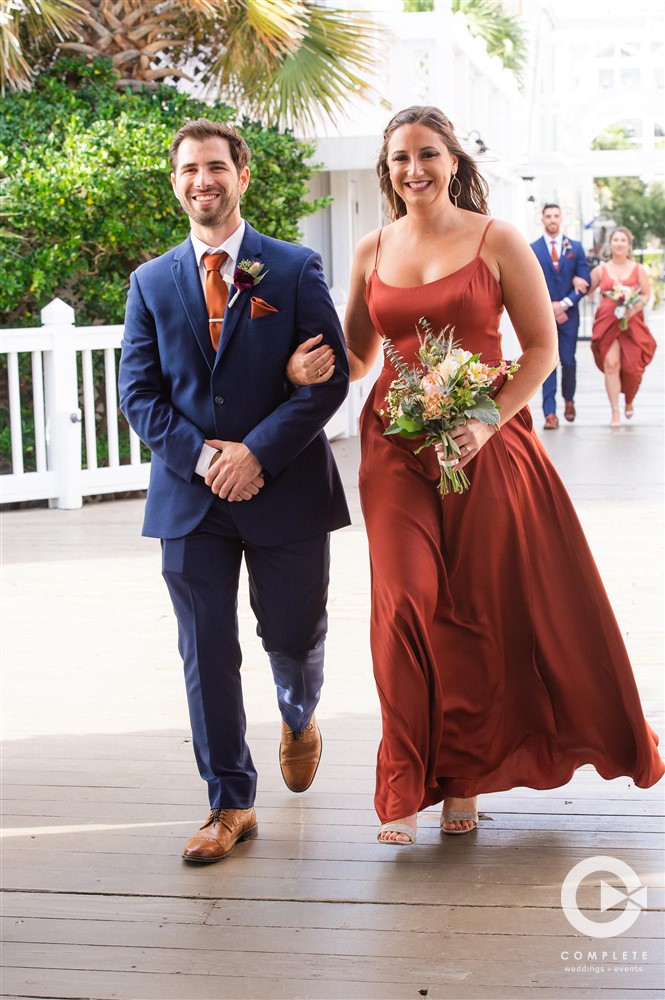 groomsman and bridesmaid walking down aisle