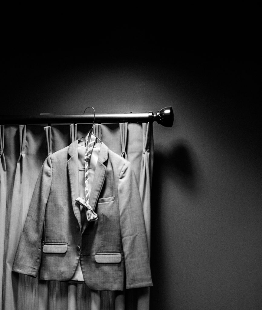 a photo of a groomsmen jacket hanging in a closet