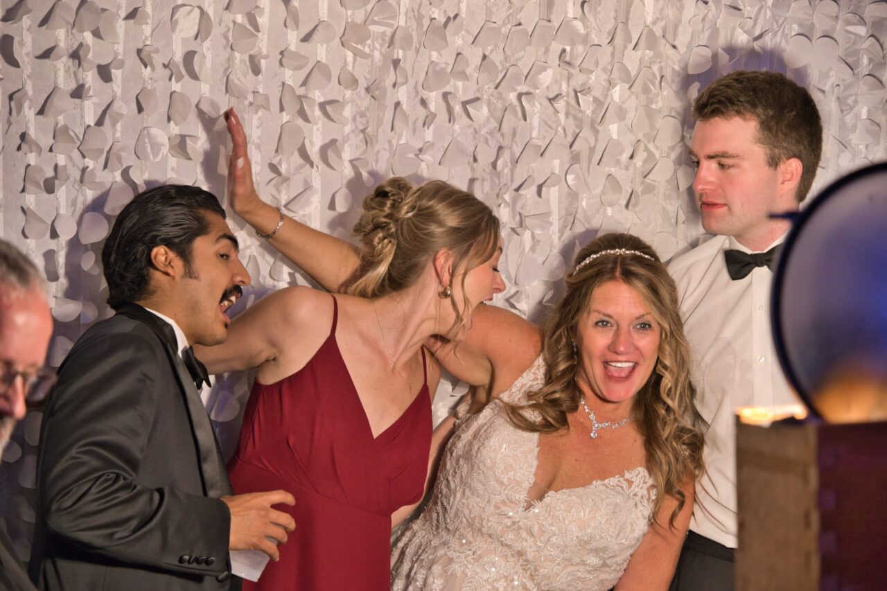 Bride and her adult kids play around at the photo booth
