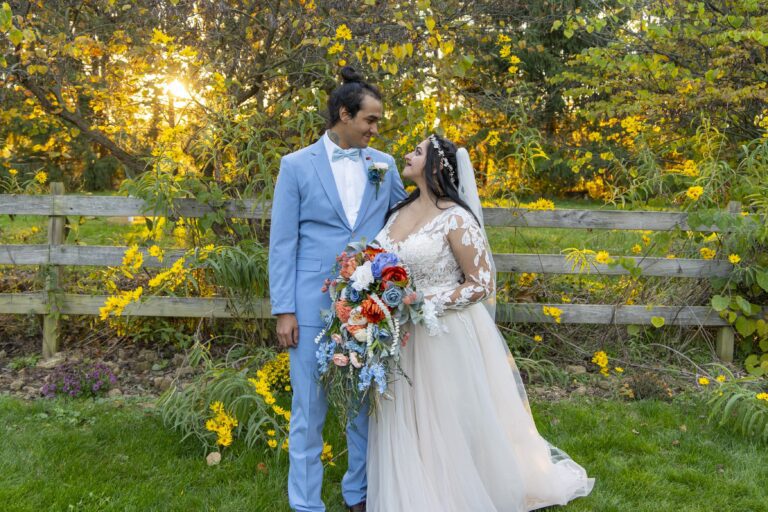 Bride and Groom gaze into one another's eyes in front of a garden with the sun poking between branches of the tree at sunset. The event photographer Michael Evans is well known for his sunset photos.