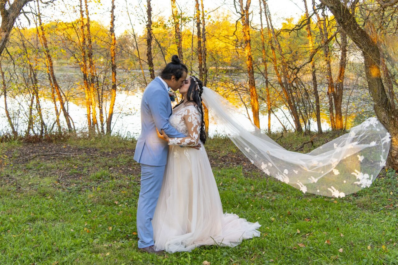 Bride and Groom kiss in front of pond in Miamisburg. Photograph by Michael Evans the owner of Complete Weddings + Events Cincinnati.