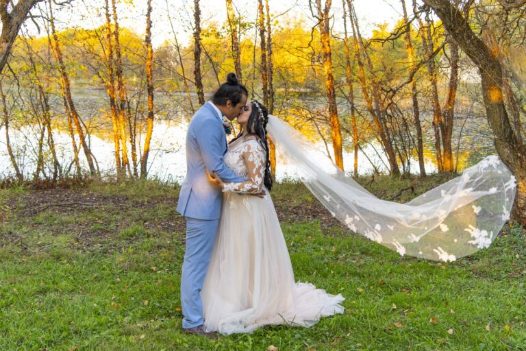 Bride and Groom kiss in front of pond in Miamisburg. Photograph by Michael Evans the owner of Complete Weddings + Events Cincinnati.