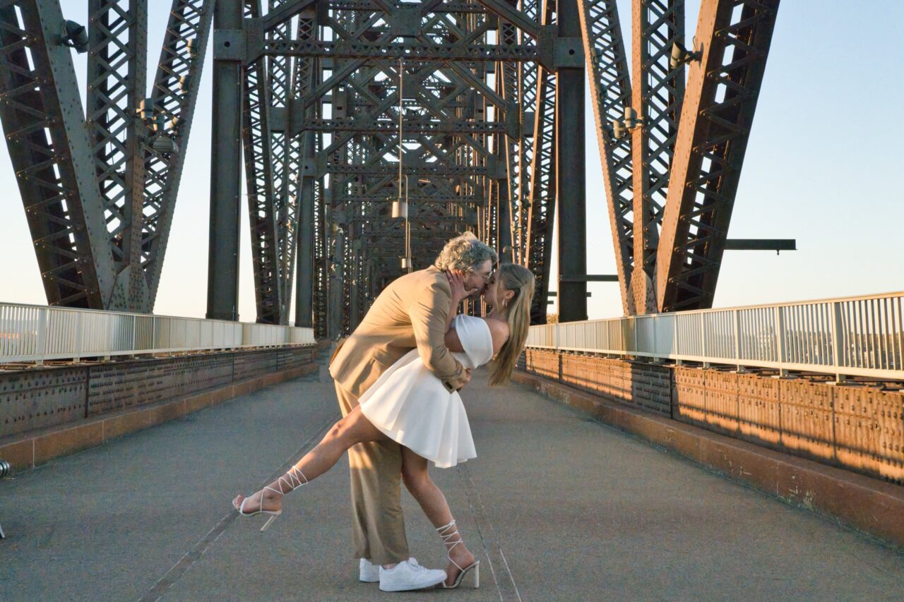 Bride and Groom kiss on bridge. Complete Weddings + Events photographer Michael Evans took the photo.