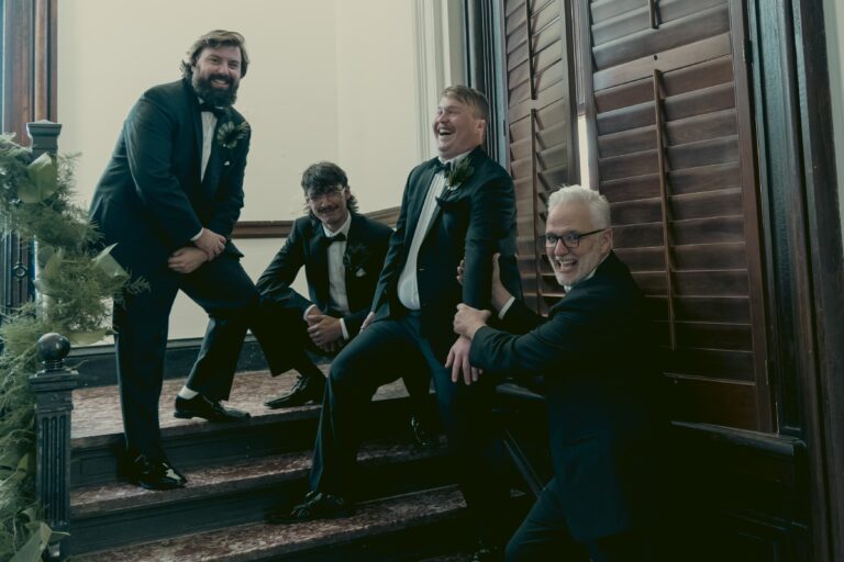 Father in law dragging the Groom down the stairs to get him to the ceremony with Groomsmen behind. Wedding Photographer Michael Evans of Complete Weddings + Events Cincinnati shot the image.