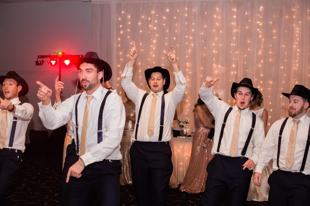 Groomsmen dancing with cowboy hats to jump on it