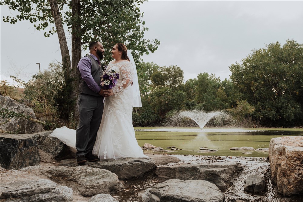 Wedding Day Advice for Brides Bride and groom kissing next to pond in Colorado Springs during wedding