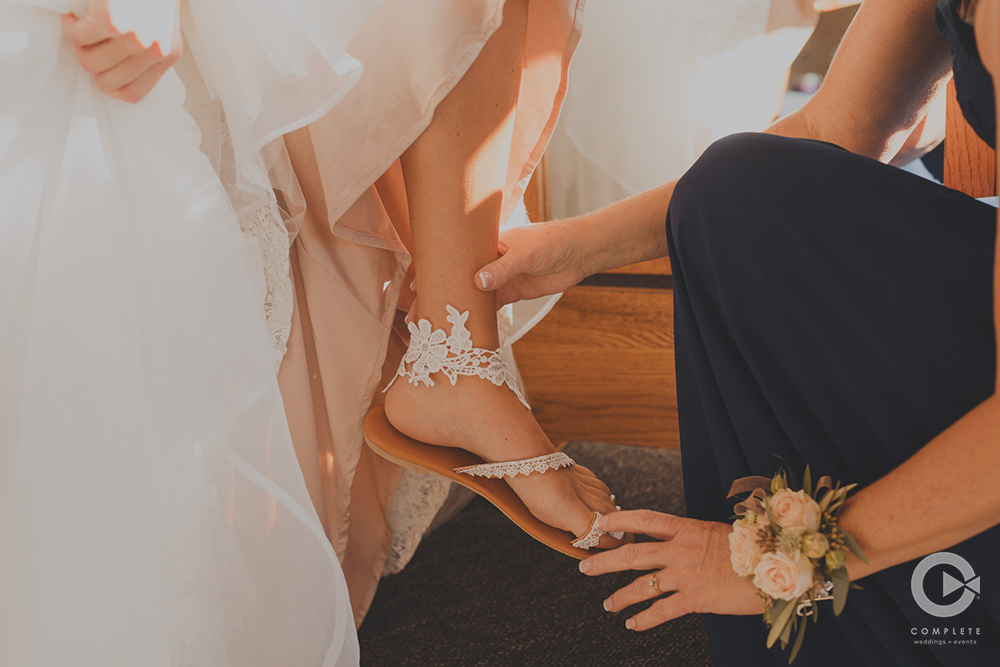 Bride putting on flats, flats vs heels and what to wear on your wedding day