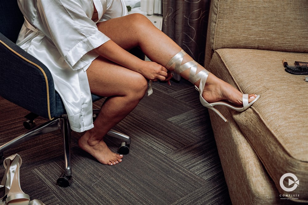 Bride putting on high heels for her New Smyrna wedding ceremony