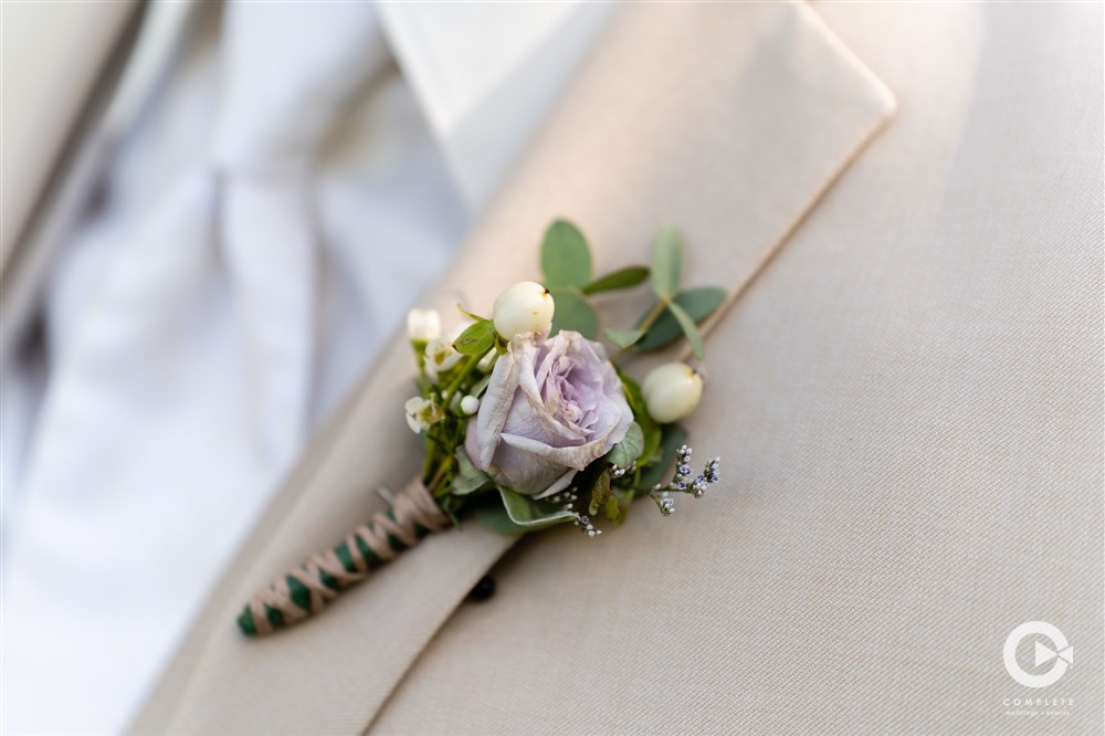 Detail shot of beautiful flower pinned on groom's suit