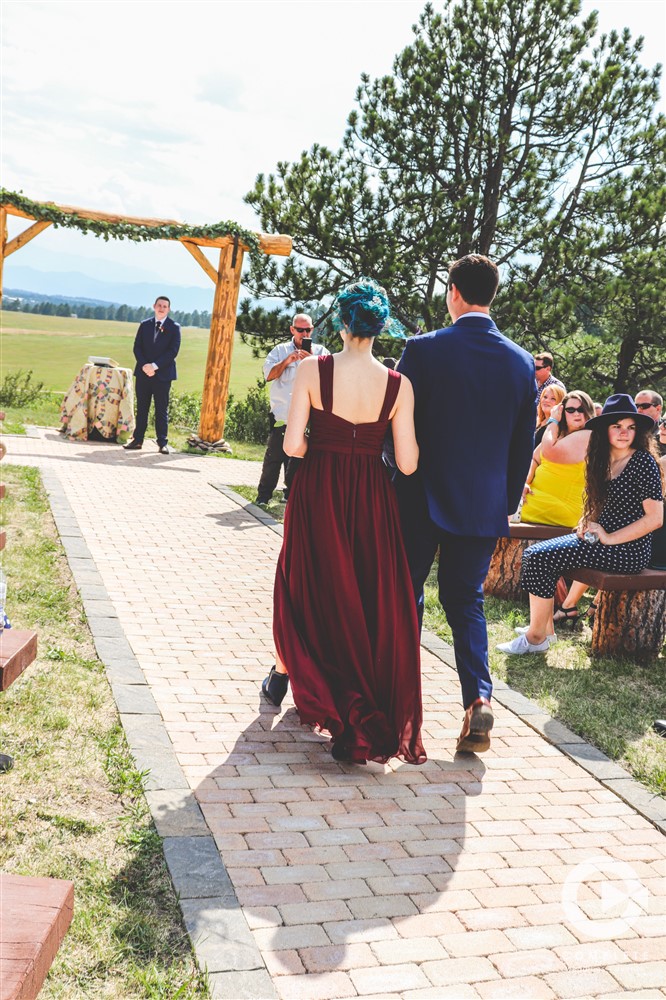 bridesmaid and groomsman walk down younger ranch ceremony path