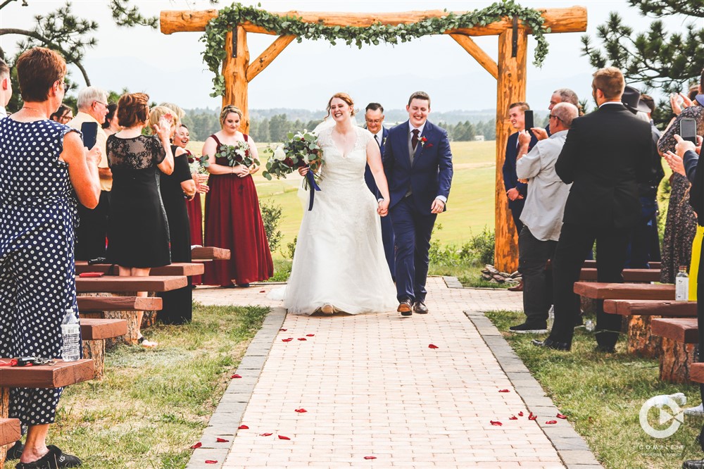 bride and groom walk back from altar at younger ranch