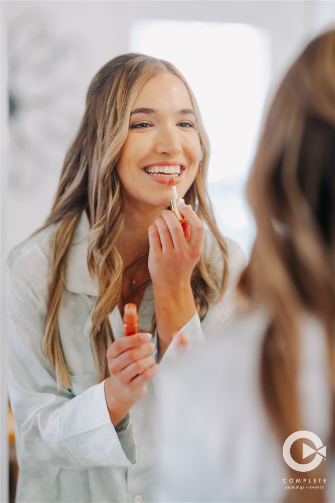 bride putting on lip gloss