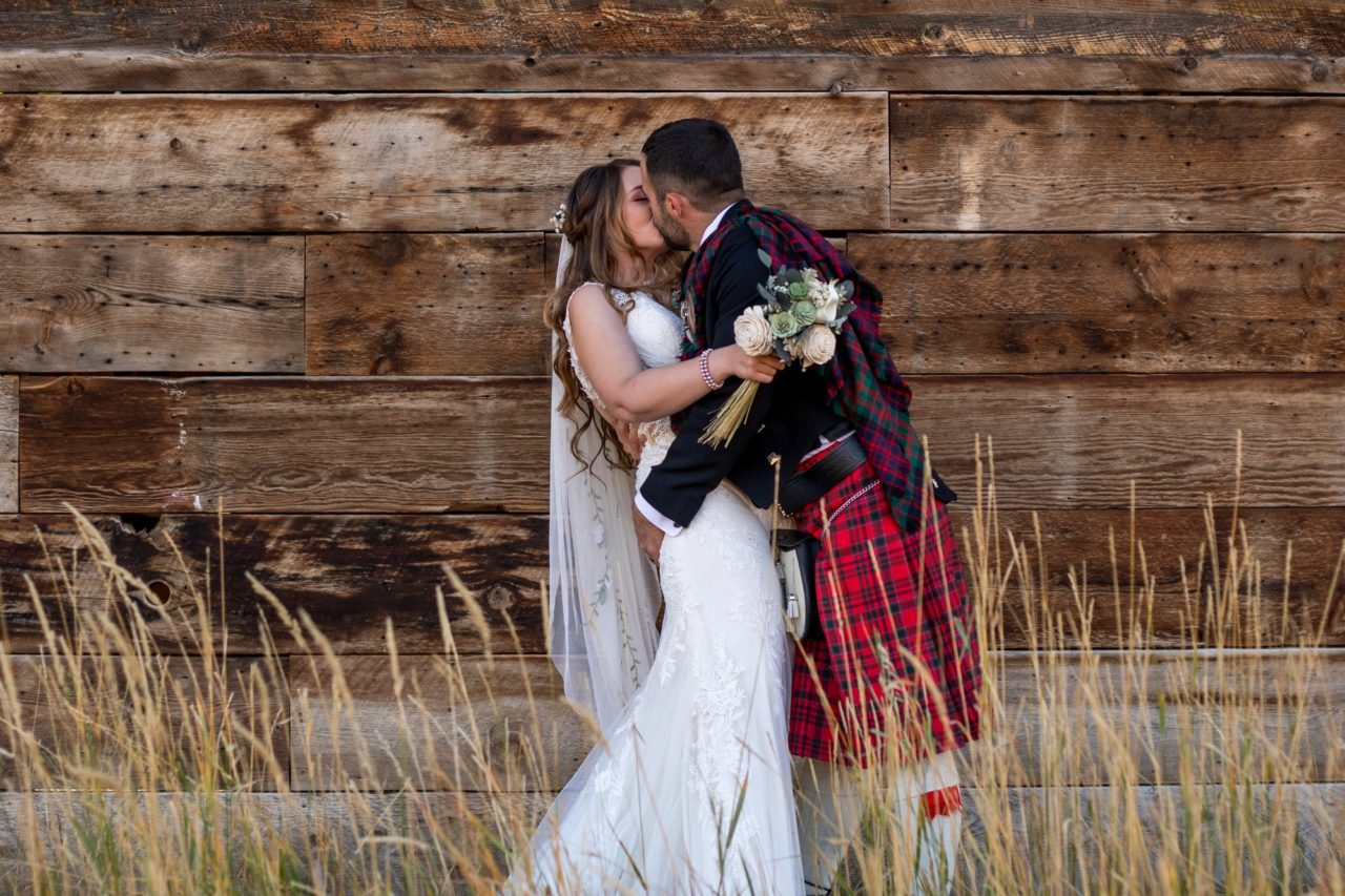 Bride and Groom kissing in front of Colorado Wedding Venue