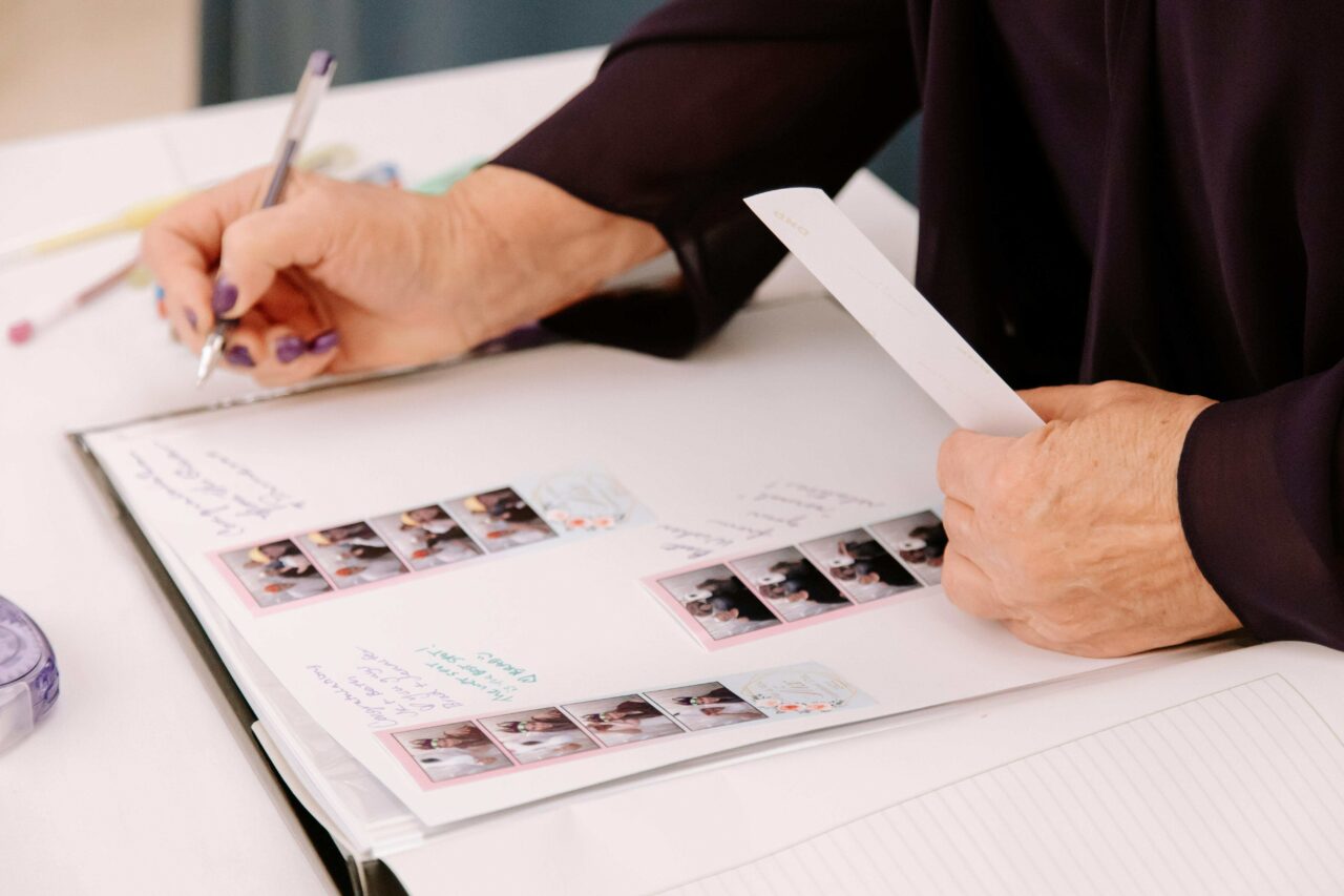 Person Signing a Photo Booth Booklet