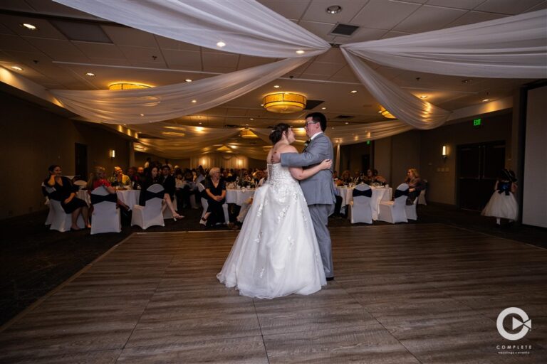 Bride and Groom first dance with everyone watching behind them