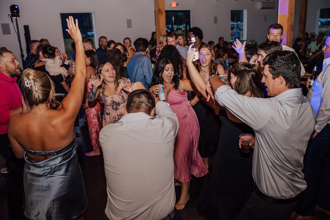 Bride and groom first dance with guests surrounding them in Duluth reception space