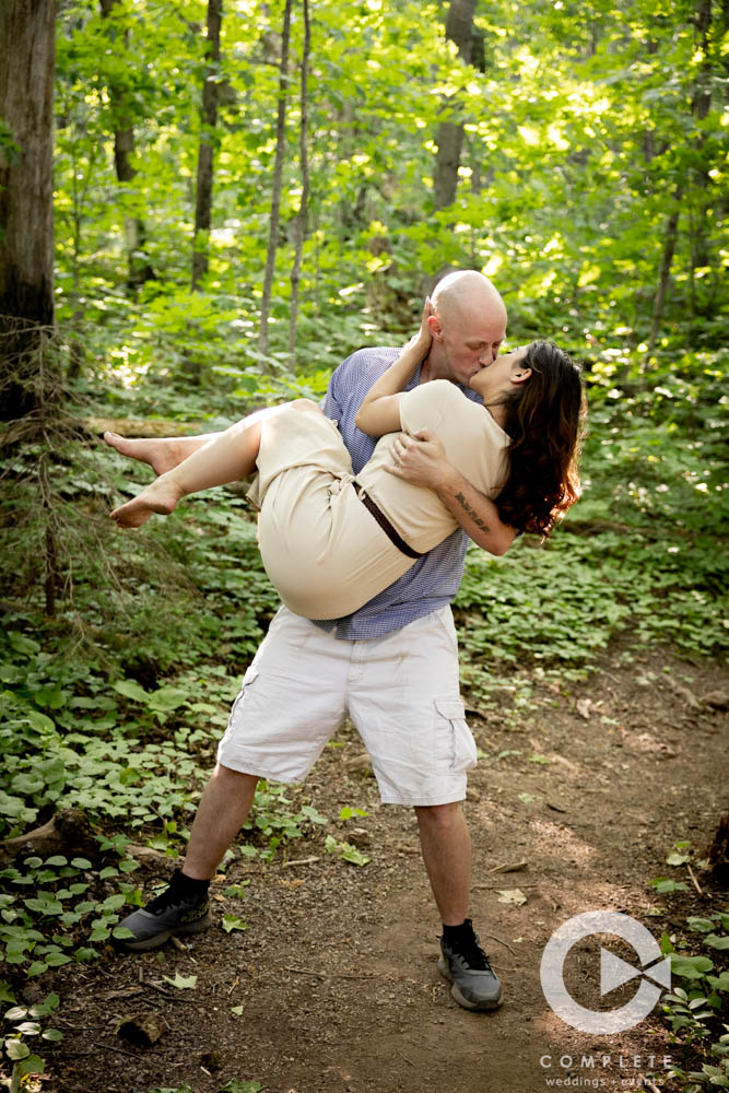 Groom cradles Bride for a kiss during engagement session in Lutsen