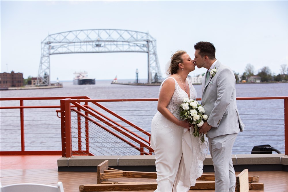 Duluth Complete Wedding and Events - Pier B - Bride and Groom Kissing - Aerial Lift Bridge