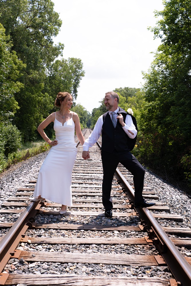 Bride and Groom looking together on railroad, Photo captured by: Complete Weddings + Events Duluth