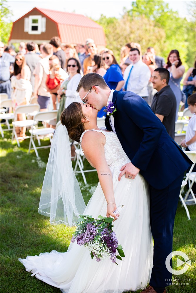 Bride and Groom first kiss during ceremony photo taken by Complete Wedding + Events Duluth