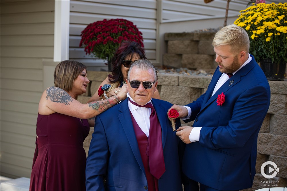 Father gets ready, all hands on deck photo taken by Complete Weddings + Events