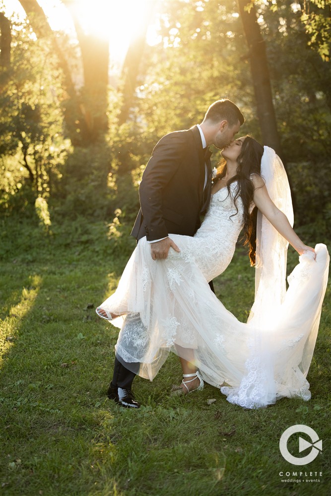 Bride and Groom kissing and dipping with sun reflecting in background