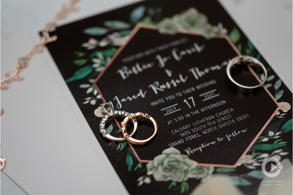 detail shot of rings and invitation