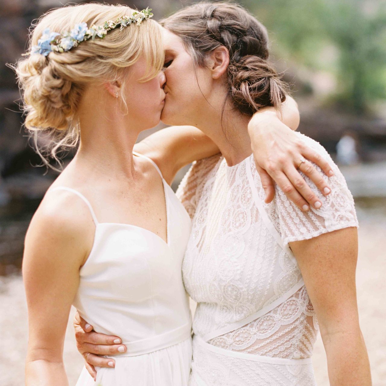 two brides kissing with bun hairstyle