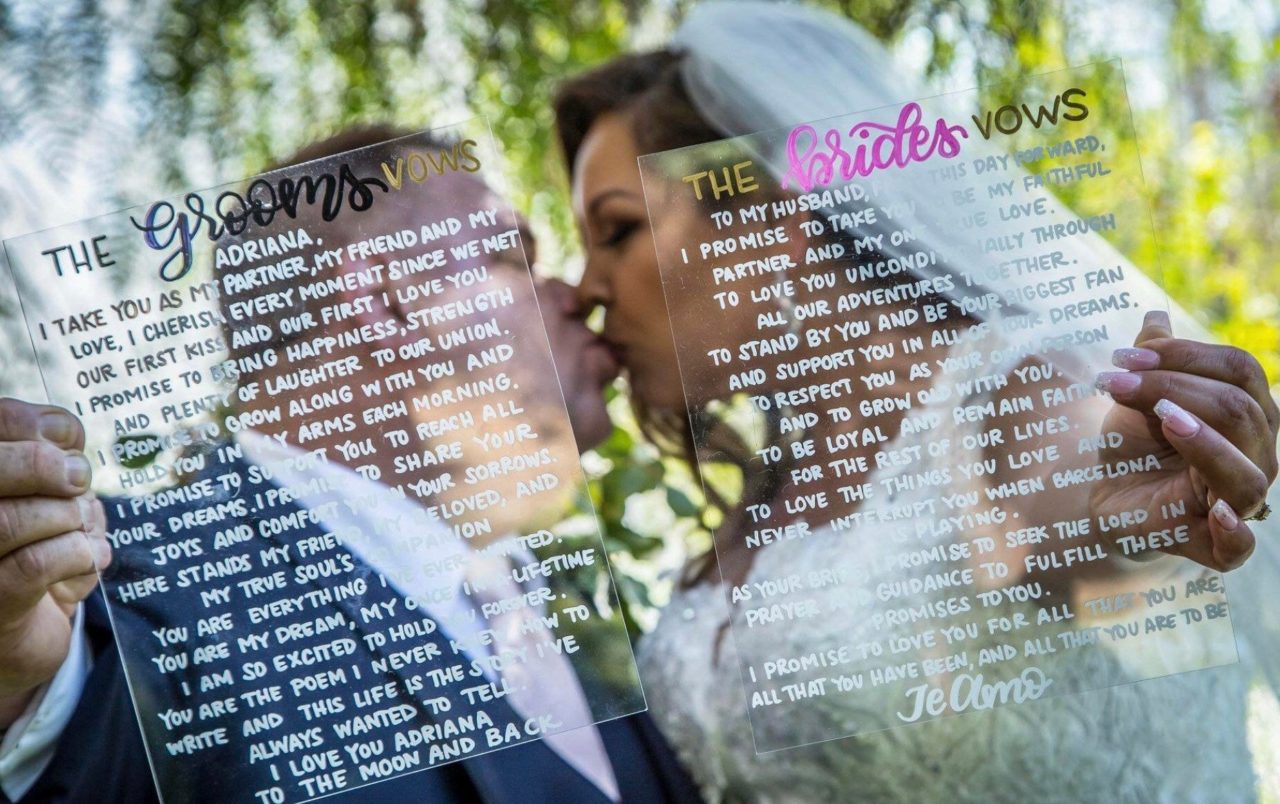 Bride and groom vows on acrylic while kissing