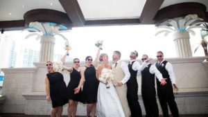 Bride, groom and wedding party posing in driveway