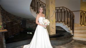 bride standing in stairway holding bouquet of flowers