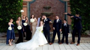 Bride, groom and wedding party posing in front of the Signature Grand