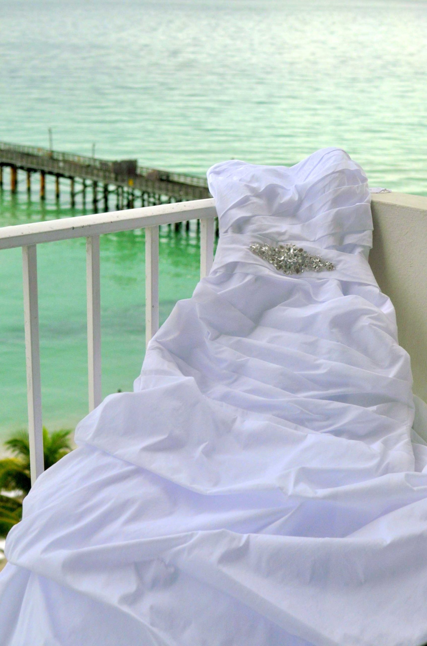 wedding gown on a balcony overlooking the beach and pier