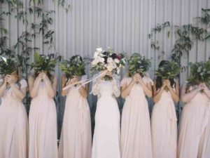 Bride and bridesmaids duties covering their faces with flowers