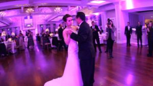 bride dancing with groom they have a purple hue due to up lights